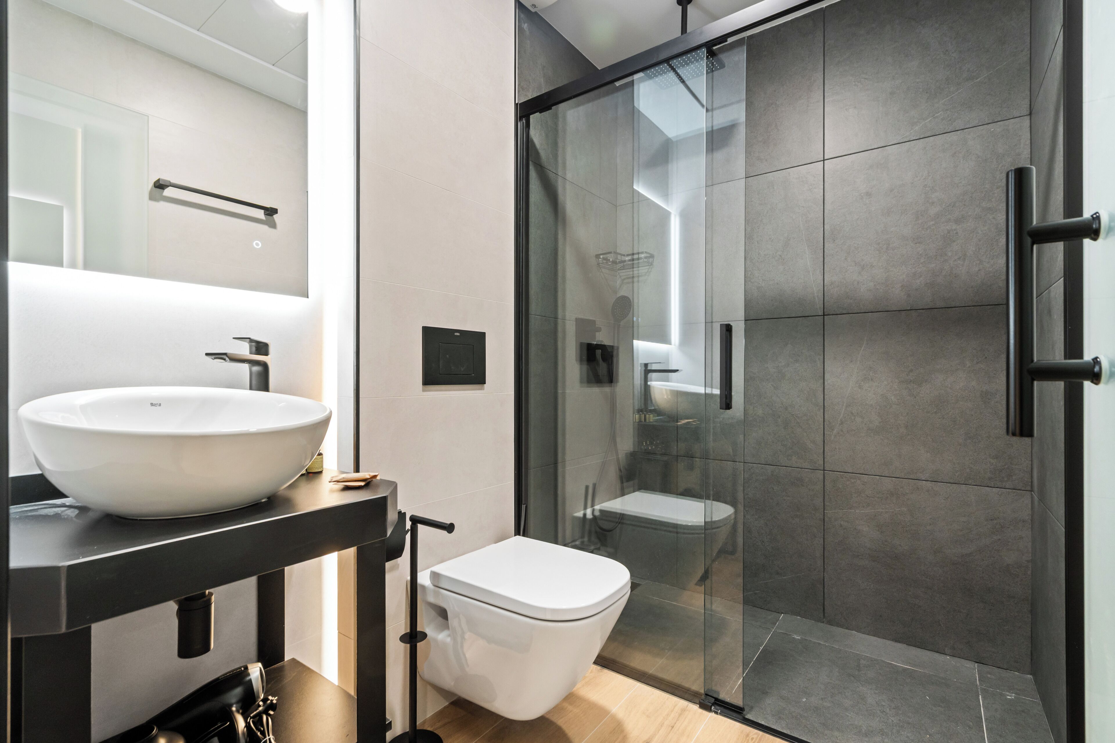 Deluxe studio | Badkamer | Een douche, een haardroger, handdoeken, zeep