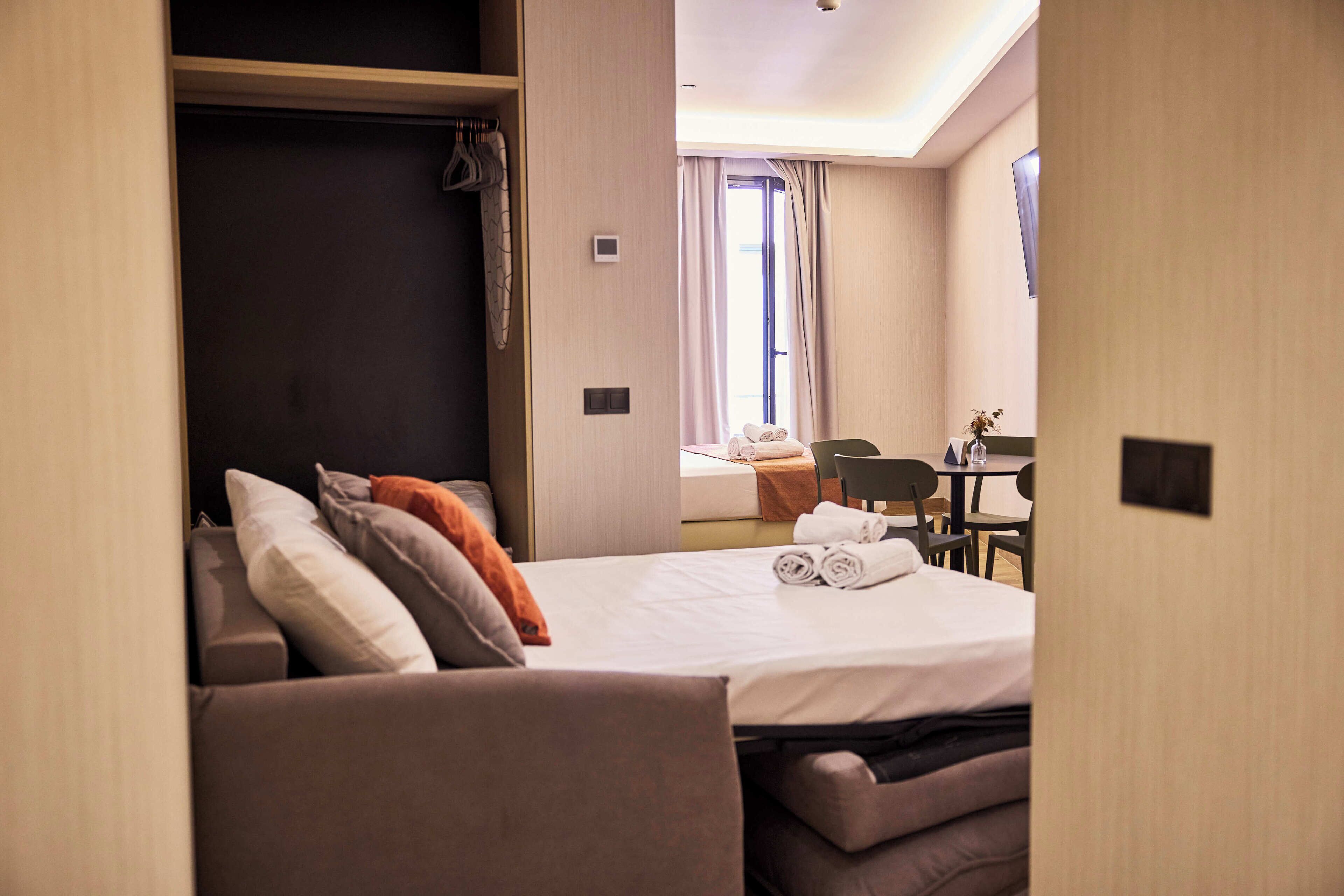 Una habitación de hotel con cama, zona de estar y escritorio.