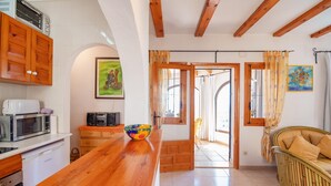 Una cocina con armarios de madera, un microondas y una encimera de madera.