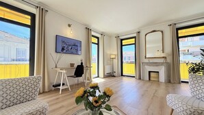 Un soggiorno spazioso con camino, ampie finestre e vista sulla città.