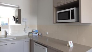 Une cuisine moderne équipée d’un four à micro-ondes, d’un évier et de placards.