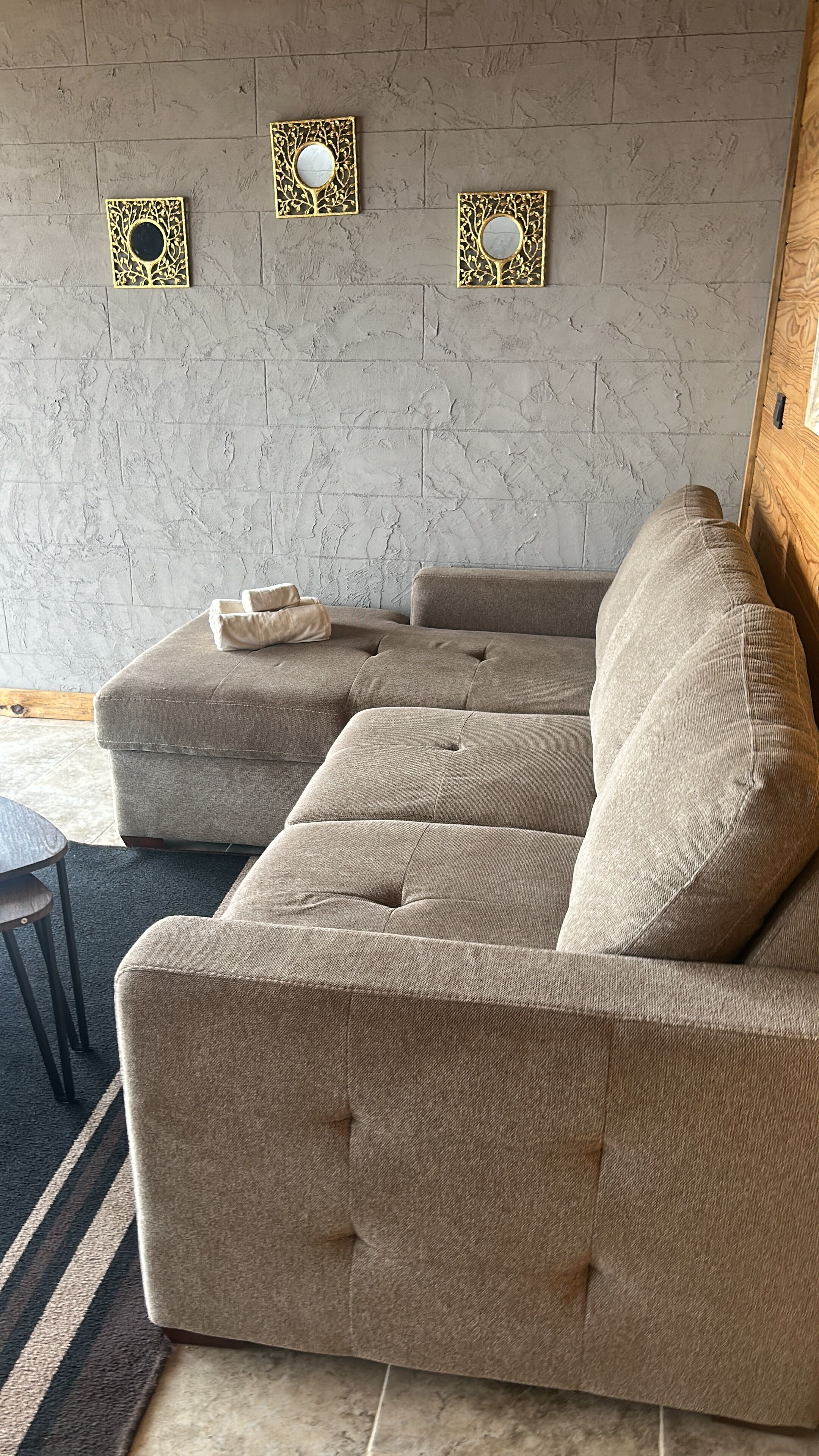 Een modulaire bank met een gestuikt design, een ronde tafel en een kamerkleed met een patroon.