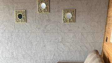 Een modulaire bank met een gestuikt design, een ronde tafel en een kamerkleed met een patroon.