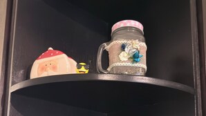 A black shelf with decorative items and spice containers.