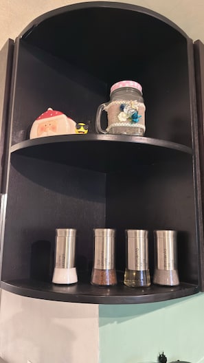 A black shelf with decorative items and spice containers. - Beautiful apartment very cozy and centrally located. Makes your stay amazing (Heroica Puebla de Zaragoza)