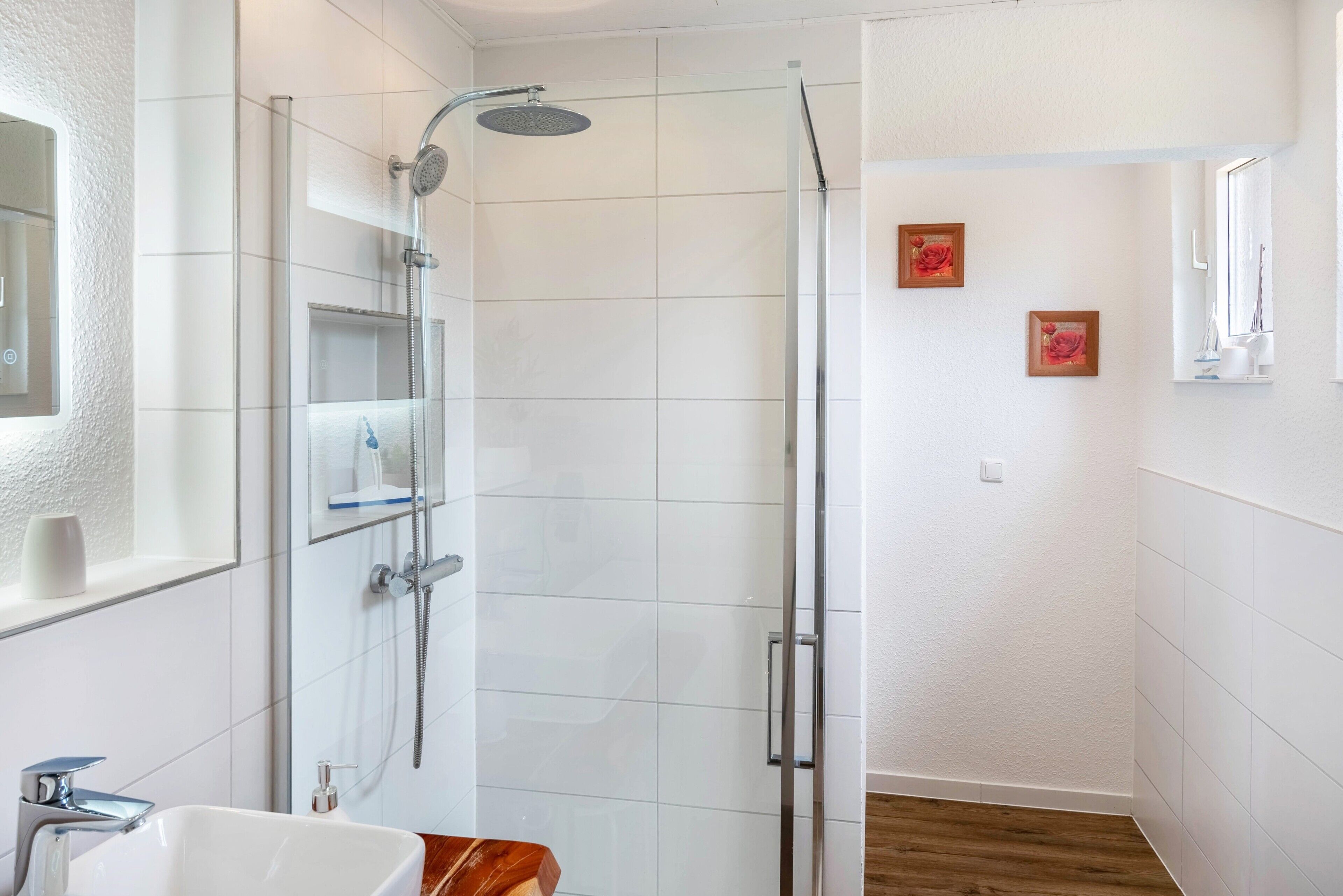 A bathroom with a shower, sink, and mirror.