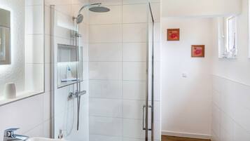 A bathroom with a shower, sink, and mirror.