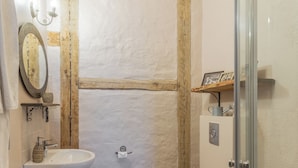 A bathroom with a white sink, a toilet, and a glass shower enclosure. - Mazmežotnes muiža (Mazmežotne)