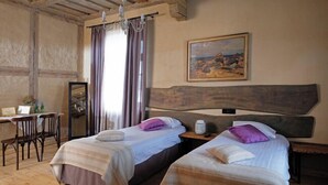 A room with two beds, a wooden desk, a chair, a mirror, and a painting on the wall. - Mazmežotnes muiža (Mazmežotne)