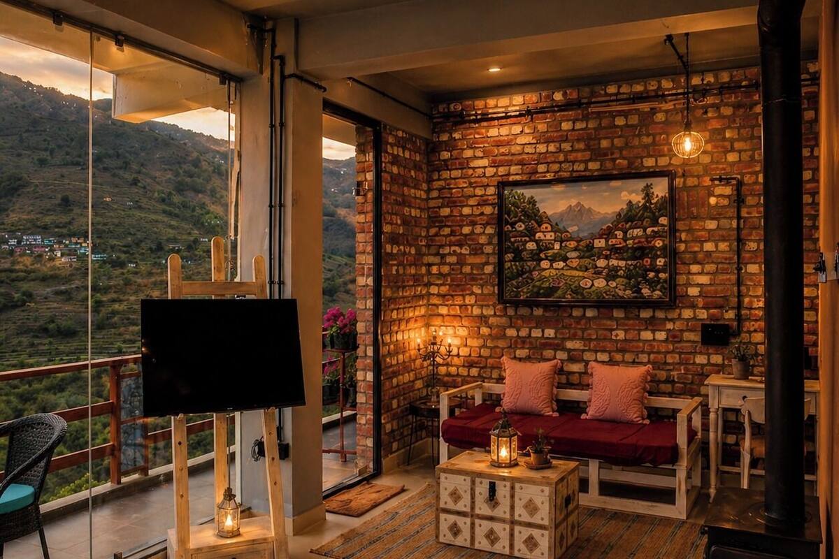A cozy room with a fireplace, a TV, and a balcony with a scenic view.
