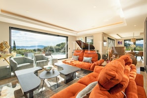 A spacious living room with a large sofa, armchairs, and a coffee table. - Magnificent Villa Semaphore sea view near beaches (Sainte-Maxime)