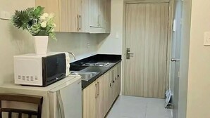 Une cuisine étroite avec des meubles en bois, un four à micro-ondes et un évier.