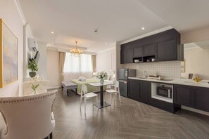 A modern hotel room with a dining area, kitchenette, and a large mirror. - Utopia Dream Apart-Hotel Nai Harn (Rawai)