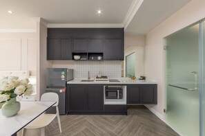 Eine moderne Küche mit dunklen Schränken, einer weißen Arbeitsplatte und einem eingebauten Backofen.