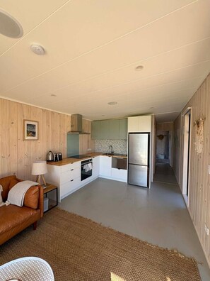 A compact kitchen with a refrigerator, stove, and sink.
