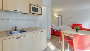 Cocina moderna con microondas, lavamanos y armarios de madera.