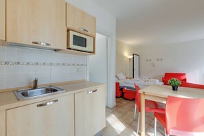 Eine moderne Küche mit Mikrowelle, Spüle und Holzschränken.