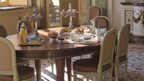 A dining room with a round table, chairs, and a chandelier. - Bed and breakfast at Château de Craon Swimming pool, tennis court, park Pdj included. (Craon)