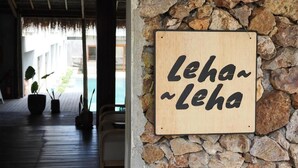 Puinen kyltti, jossa lukee ”Leha ~ Leha”, on kiinnitetty kiviseinään.