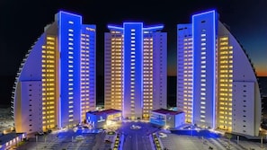 Un hotel con varias torres, un patio central y una zona de estacionamiento.