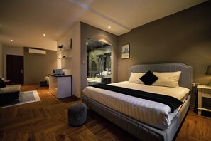 A modern bedroom with a large bed, a desk, and a walk-in closet. - Atlantis Nguyen Truong To (Ba Dinh)