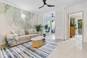 Ein Wohnzimmer mit einer Couch, einem Couchtisch und Pflanzen.