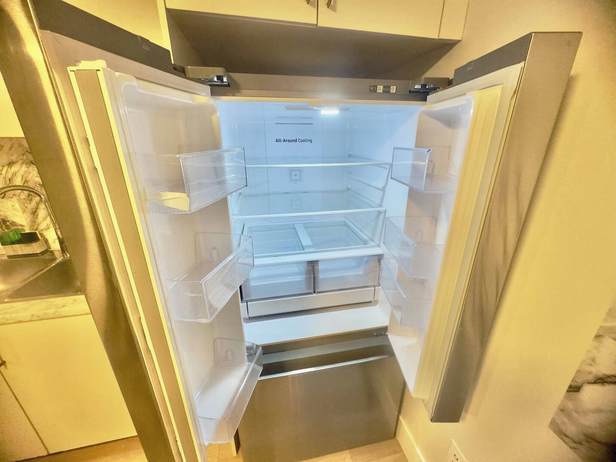 An all-around cooling refrigerator with multiple transparent drawers and a stainless steel finish.