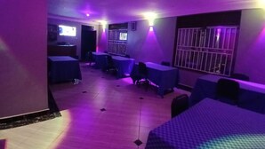 A room with a tiled floor, a bed, a desk, and a chair. - PANDA HOTEL (Entebbe)