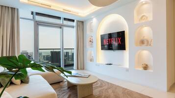 Apartamento luxo, vista para a cidade | Área de estar | Smart TV 65 polegadas com canais digitais