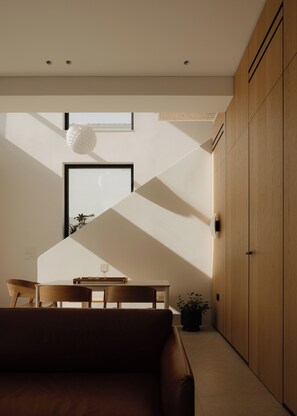 A modern interior with a dining area, a sofa, and a wooden wardrobe. - The Habitus Project (Kerkira)