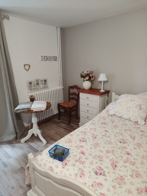 A bedroom with a bed, a desk, a chair, a dresser, and a radiator. - The serenity effect (Saint-André-de-Cruzières)