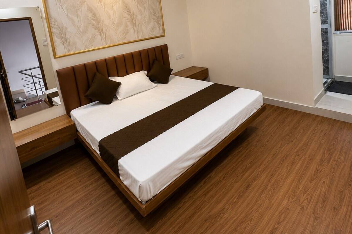 Un dormitorio moderno con cama, ventilador de techo, aire acondicionado y un ventanal grande.