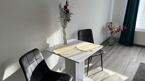 A modern dining area with a white table, black chairs, and a vase with flowers. - Cozy forest house / Przytulna Chatka w Lesie (Mątki)