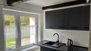 A kitchen with a window, a radiator, and a kettle. - Cozy forest house / Przytulna Chatka w Lesie (Mątki)