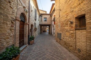 A narrow stone-paved alleyway between buildings with arched doorways and windows. - Room of Light close to Assisi (Petrignano di Assisi)