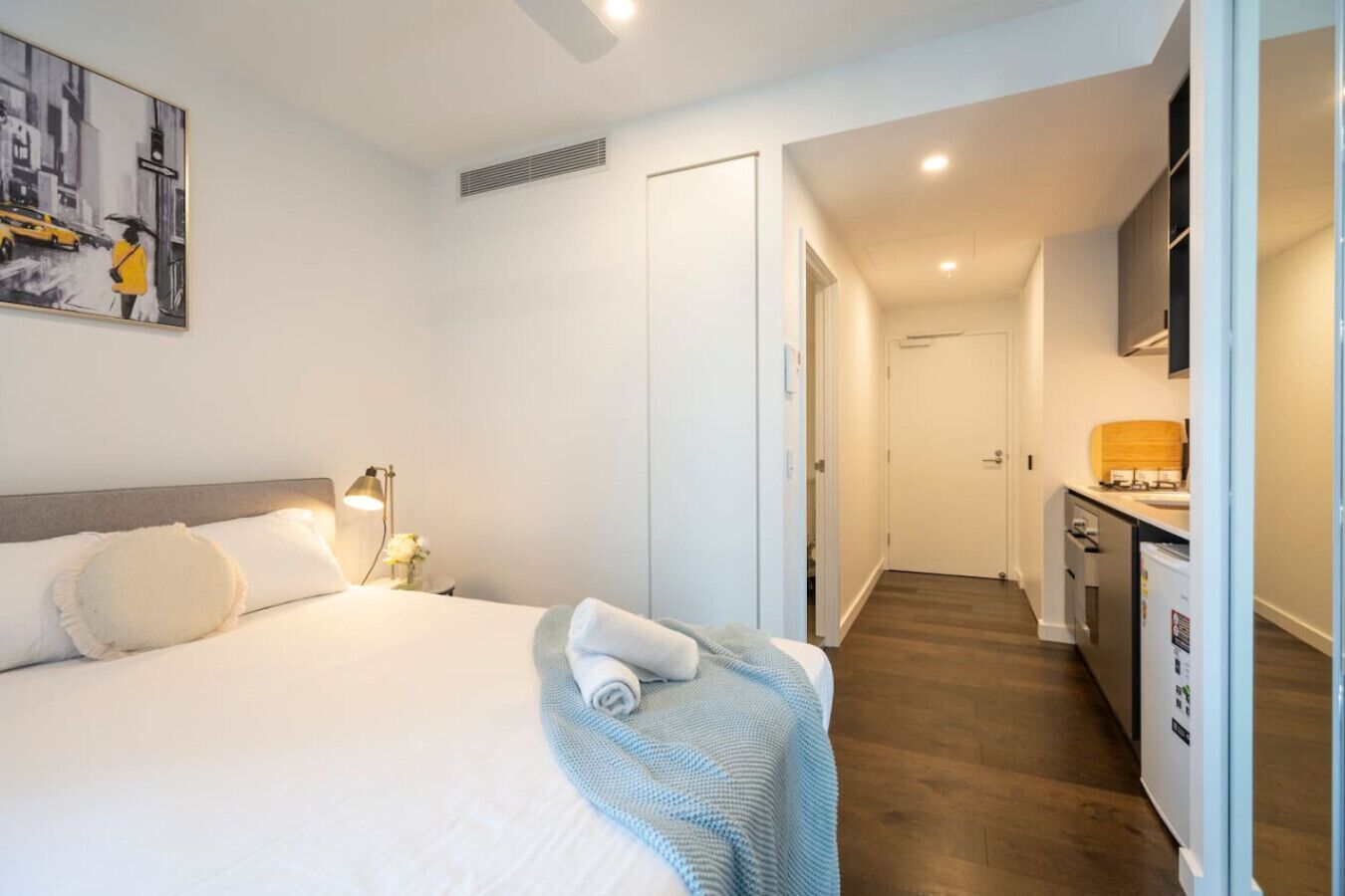 Une chambre d’hôtel avec un lit, une lampe de chevet et un tableau au mur.