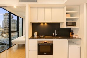 A modern kitchen with a built-in oven, microwave, and a coffee machine. - Modern Studio w/ Pool, Gym, Views - South Brisbane (South Brisbane)