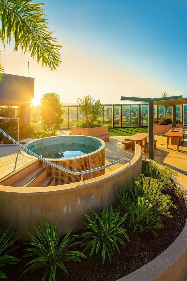 A rooftop pool area with a hot tub, outdoor seating, and a view of the cityscape. - Modern Studio w/ Pool, Gym, Views - South Brisbane (South Brisbane)