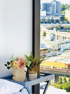 A balcony with a flower arrangement and a small plant in a burlap bag. - Modern & Vibrant - 1 BR Apt - Pool/Gym/Sauna (South Brisbane)