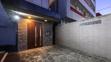 Una entrada de edificio con fachada de piedra, una puerta de madera y un letrero que dice 'Wilshire Ave'.