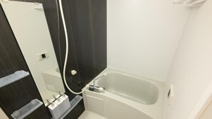 Separate tub and shower, hair dryer, slippers, towels