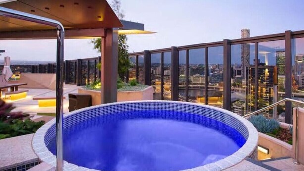 Una piscina en la azotea con vistas a la ciudad.