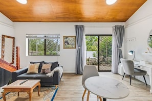 Ein Wohnzimmer mit einer Couch, einem Couchtisch und einem Essbereich mit Tisch und Stühlen.