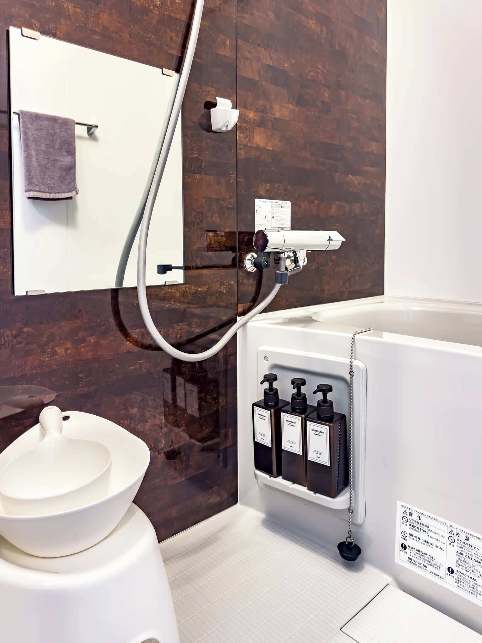 A modern bathroom with a toilet, a shower, and a sink.