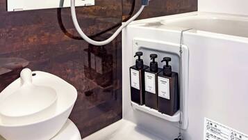 A modern bathroom with a toilet, a shower, and a sink.