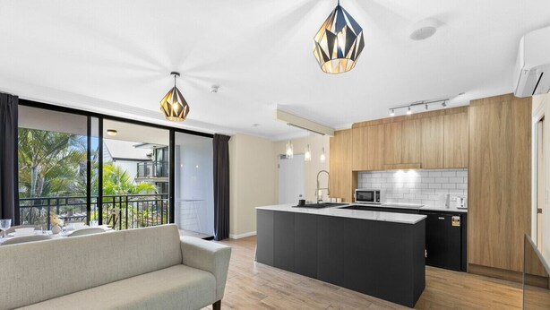 A modern apartment with a living area, a balcony, a kitchen, and a dining area. - Modern Tropical 1BR Oasis in Spring Hill (Spring Hill)