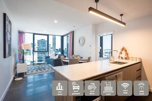 Eine moderne Wohnung mit Essbereich, Küche und großen Fenstern mit Blick auf die Stadt.