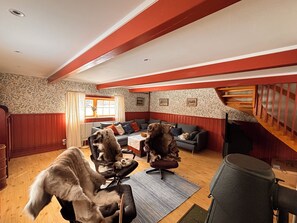 Ein gemütliches Wohnzimmer mit Kamin, einer Couch, einem Couchtisch und einem Hund.