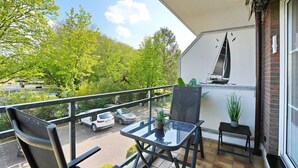A balcony with a table, chairs, and a sailboat mural. - Seesternresidenz Apartment 19 - Seesternresidenz (Scharbeutz)