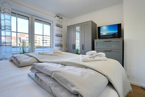 Ein Hotelzimmer mit einem Bett, einem Fernseher und Blick auf Gebäude.